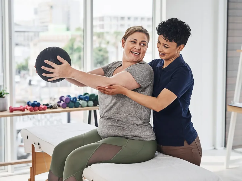 A licensed physical therapist checking hip motion during an evaluation in Reseda
