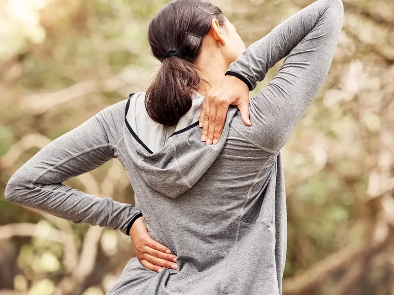 A licensed physical therapist assessing low back and hip movement during an evaluation in Reseda