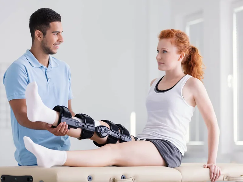 A licensed physical therapist guiding a patient through post-surgical rehabilitation in Reseda
