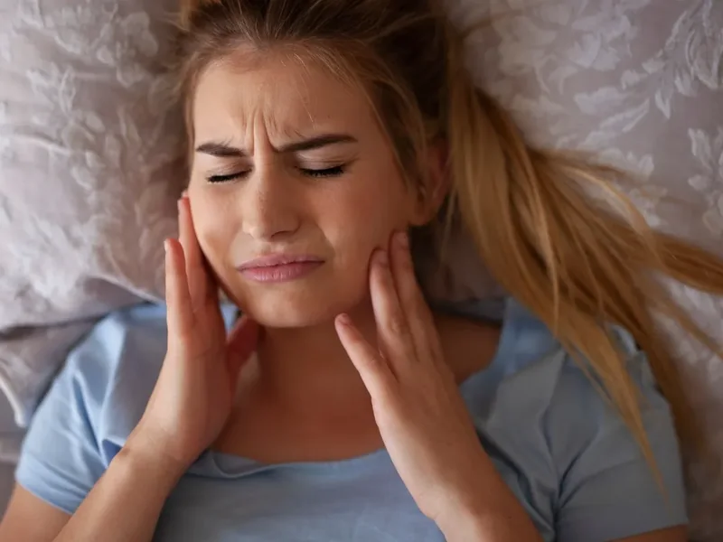 A licensed physical therapist assessing jaw and neck movement in Reseda