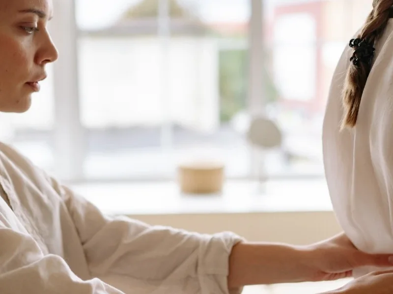 A therapist&rsquo;s hands working on a patient&rsquo;s lower back to settle the pain down
